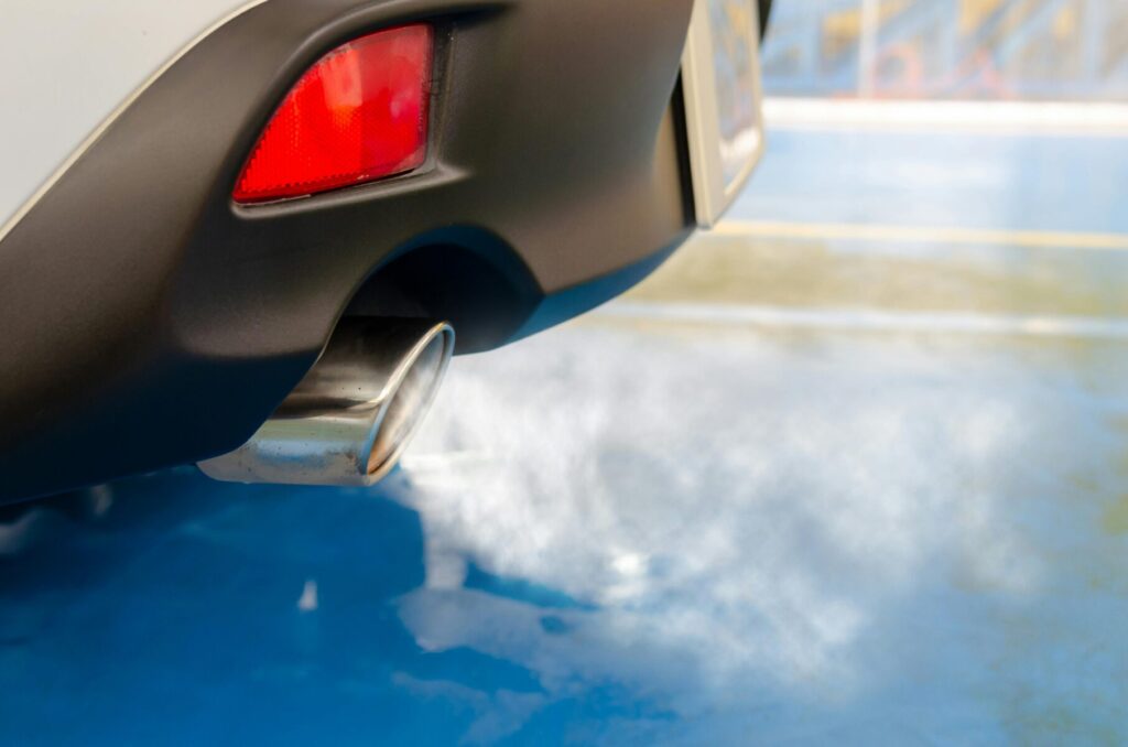 A picture of tailpipe exhaust coming out of a sedan vehicle
