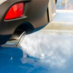 A picture of tailpipe exhaust coming out of a sedan vehicle