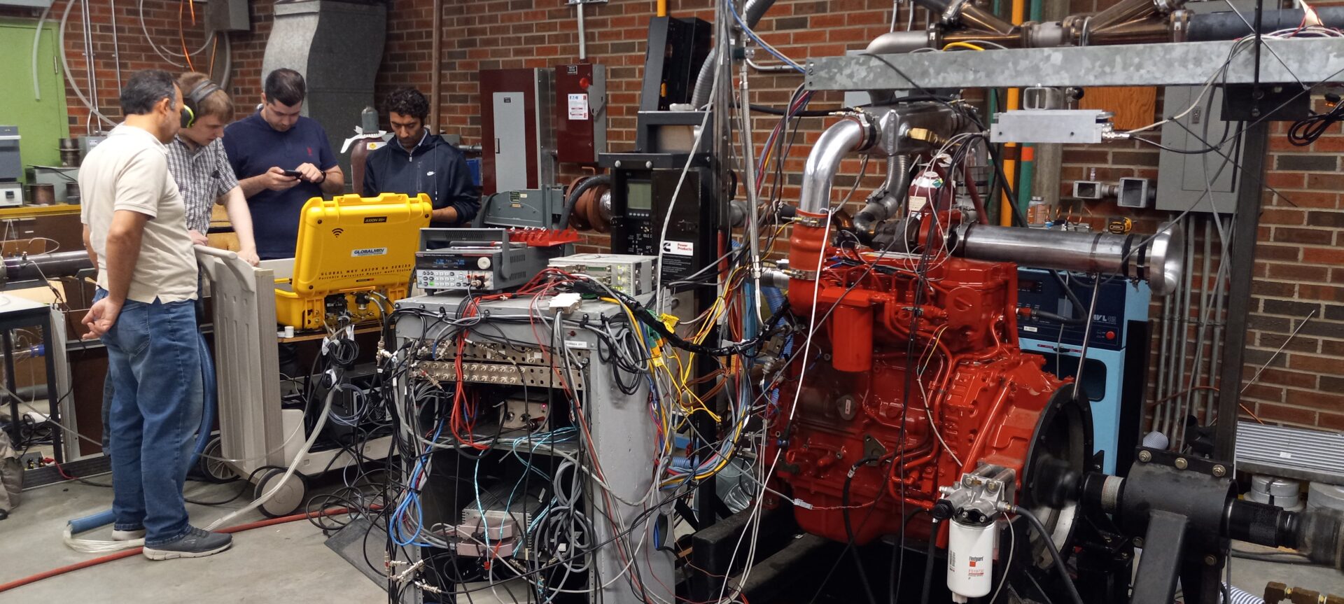 A picture of a team around a PEMS unit with copper wiring everywhere