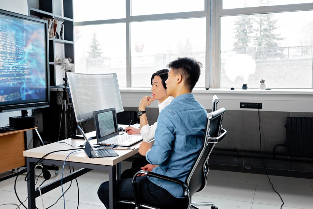 People staring at computer screens and gesturing to a virtual lab